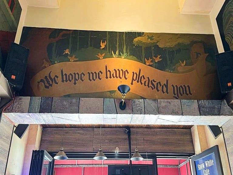 "We hope we have pleased you" mural at the Snow White Cafe